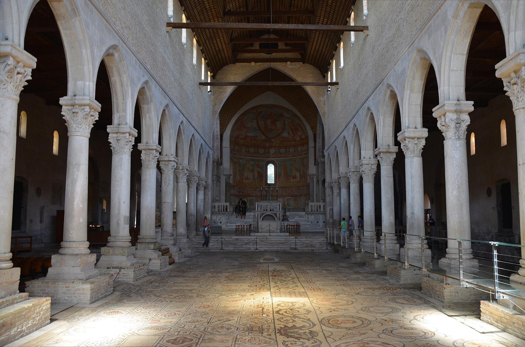 Nave of Aquileia Basilica with arcades, frescoed apse and mosaic floor
