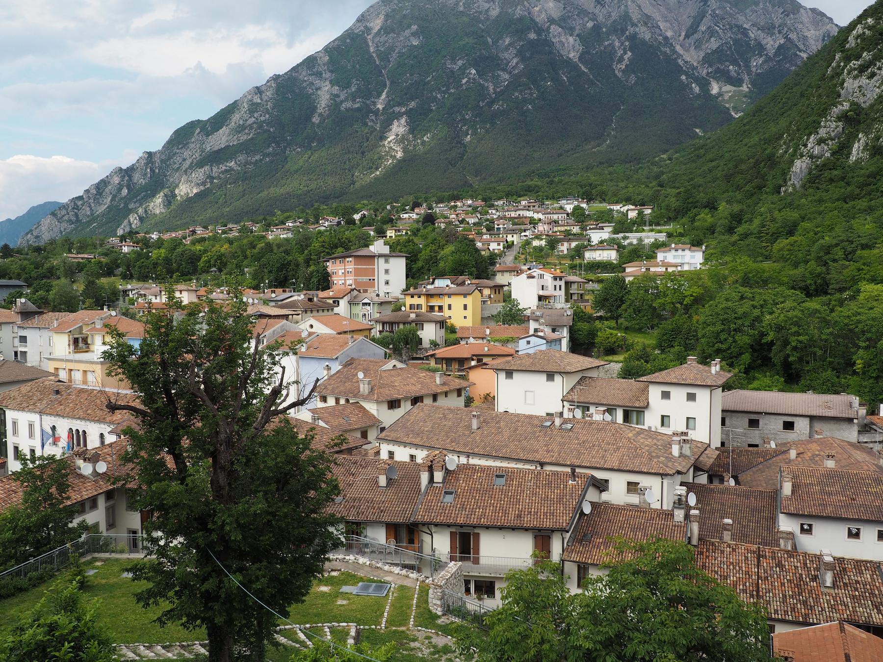 Rooftops of Gemona del Friuli spreading beneath a towering limestone mountain