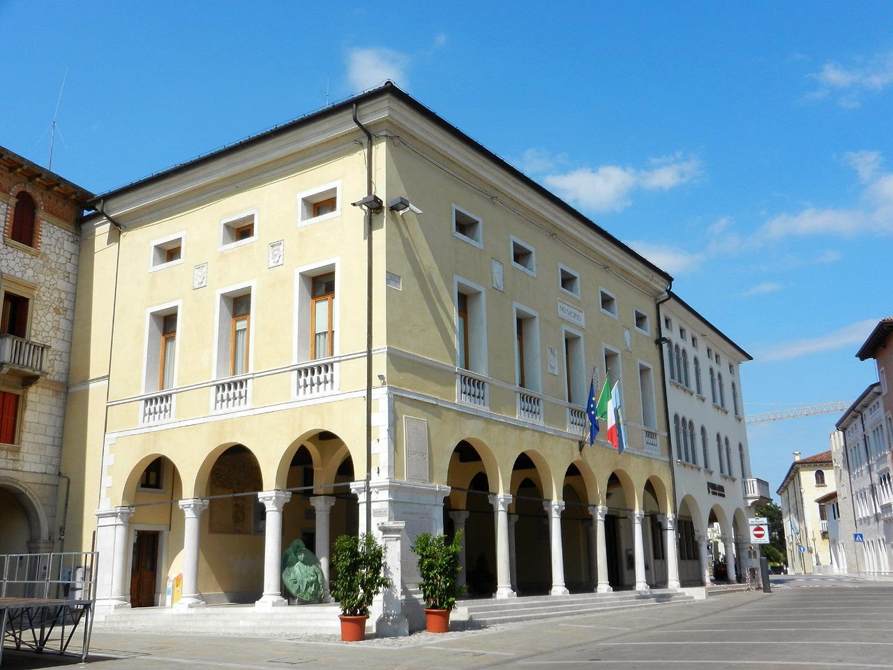 Arcaded town hall on Piazza del Popolo in Sacile under blue sky