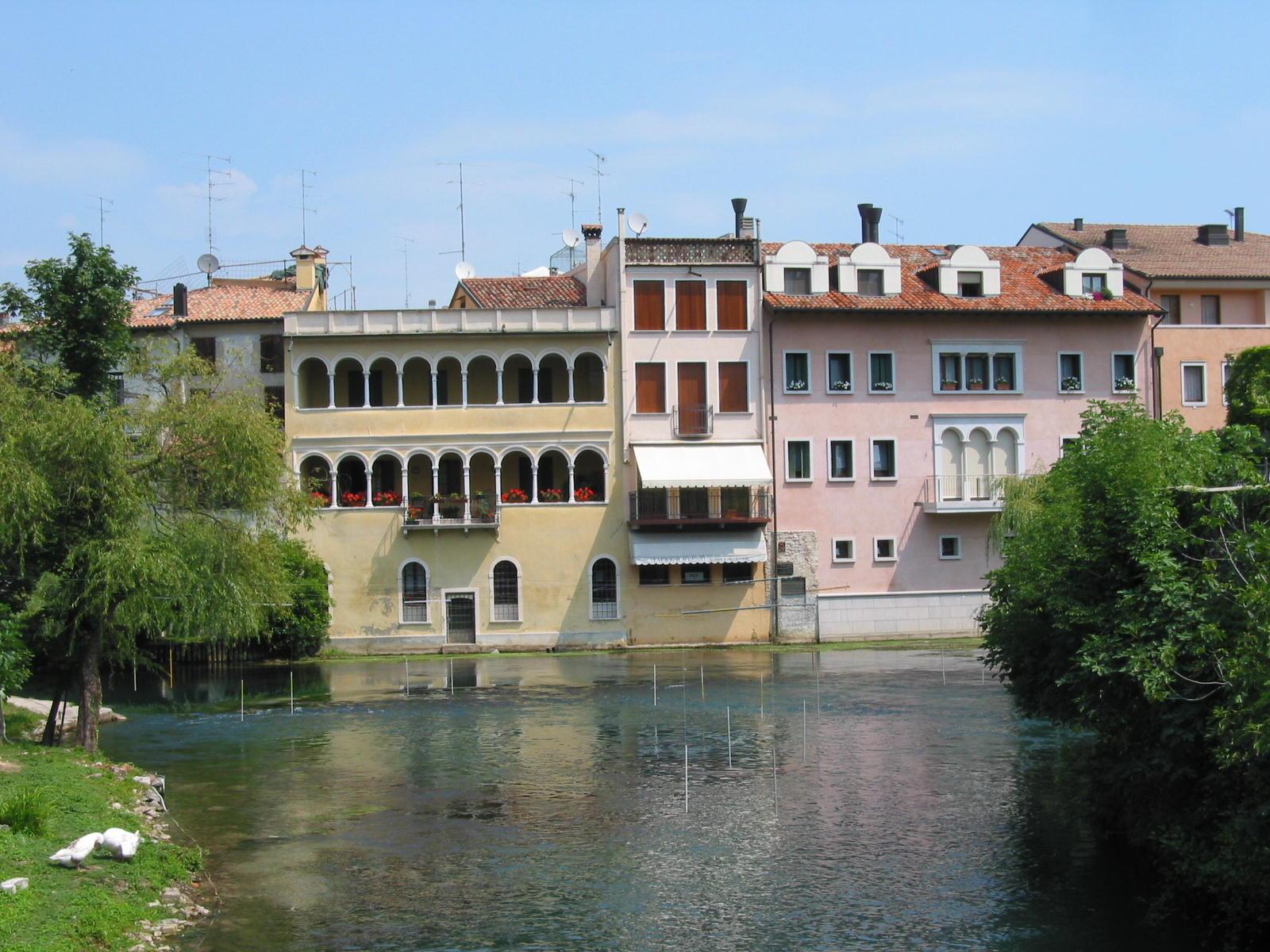 Pastel Venetian palaces reflected in the clear Livenza river, Sacile