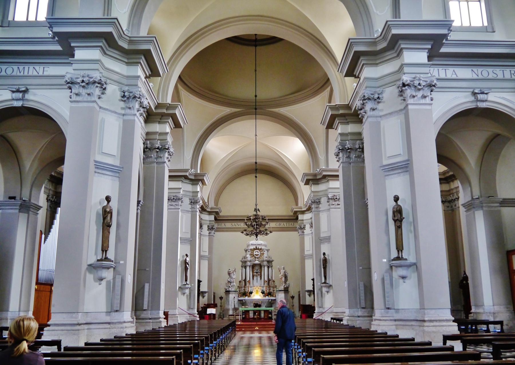 Bright white nave of San Daniele cathedral looking toward the high altar