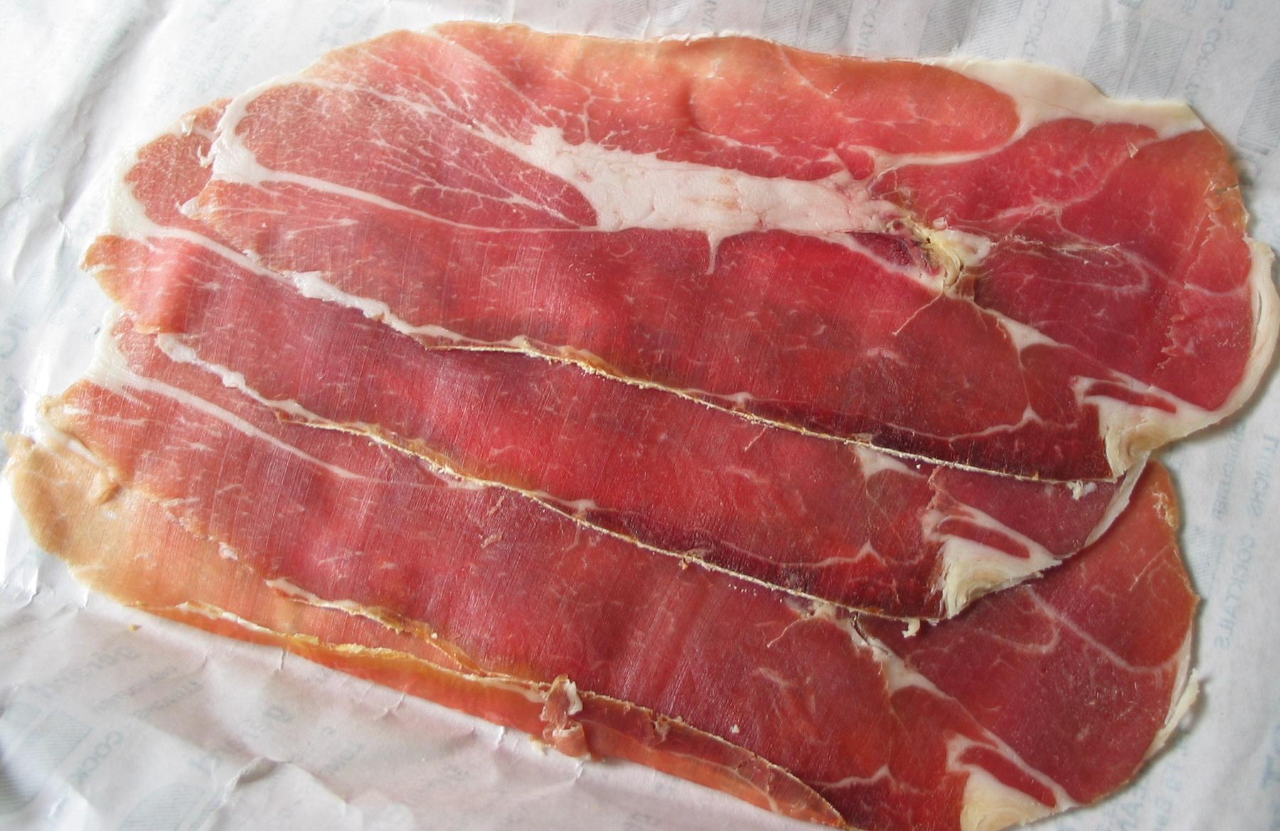 Thin, delicate slices of Prosciutto di San Daniele on paper
